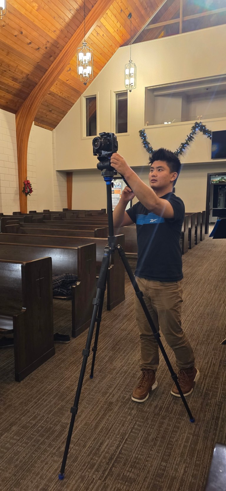 Ryan setting up a camera on a tripod for an event shoot