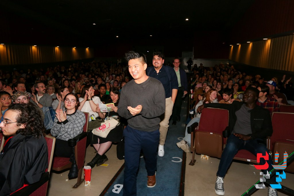 Ryan walking through a cheering cinema audience at a film festival screening