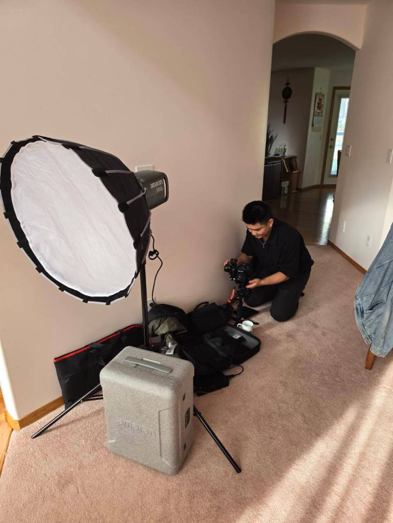 Ryan preparing camera gear beside a softbox light on an in-home shoot